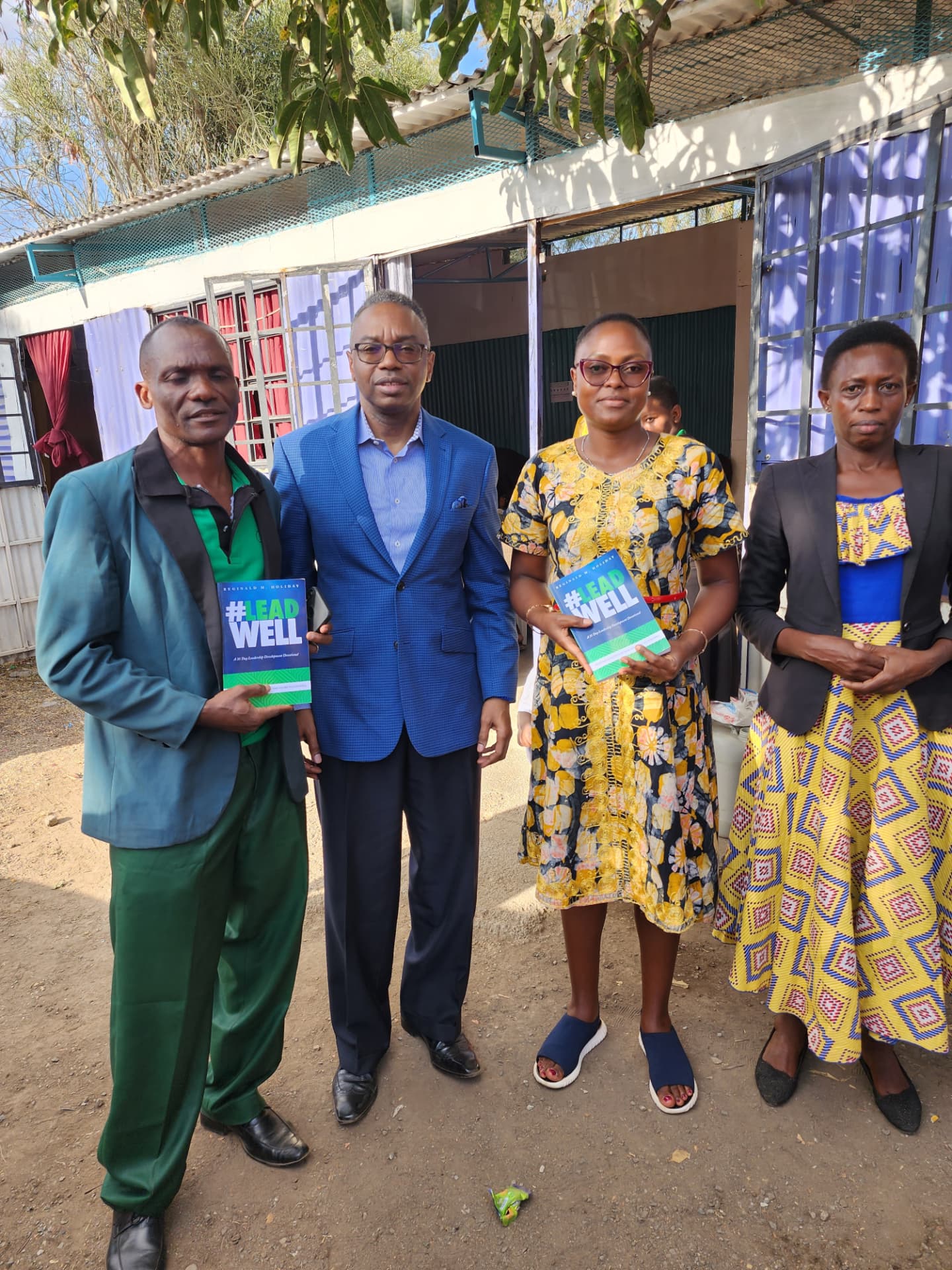 Reggie Holiday standing with local ministry leaders holding copies of his book #LeadWell.