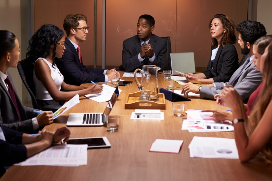 An advisory engagement in progress — an executive speaking around a boardroom table